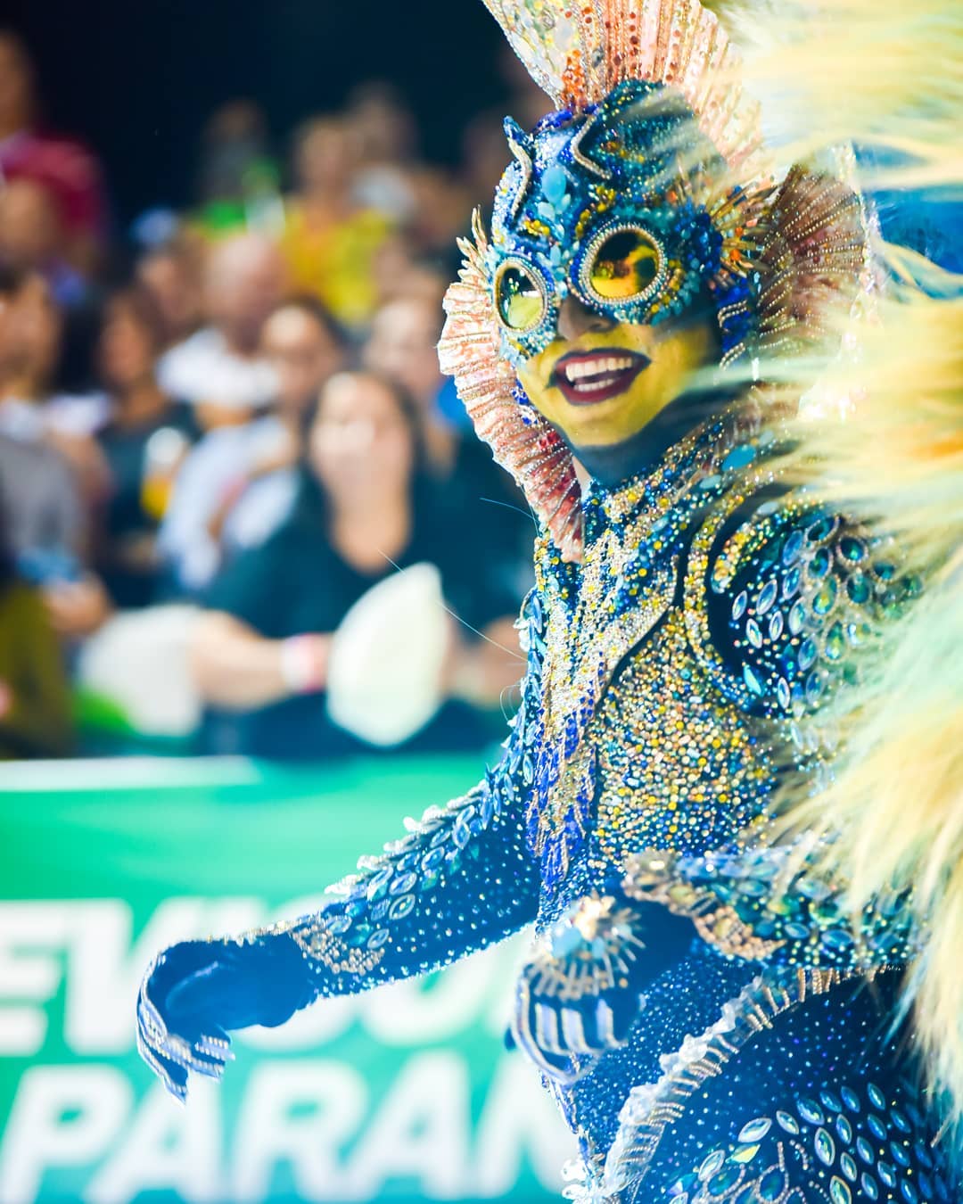 Retrato de un participante del Carnaval de Corrientes con máscara azul, dorada y plumas.